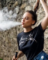 Brunette girl is vaping outdoor summer lifestyle
