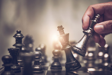 Businessman moving chess piece on chess board game concept for ideas and competition and strategy, business success concept, business competition planing teamwork strategic concept. - obrazy, fototapety, plakaty