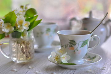 Tea drinking. Cups with tea and a vase with a jasmine.
