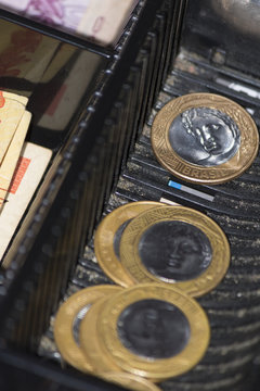 Saleswoman hands at cash register with brazilian money notes and coins inside the electronic cash register 