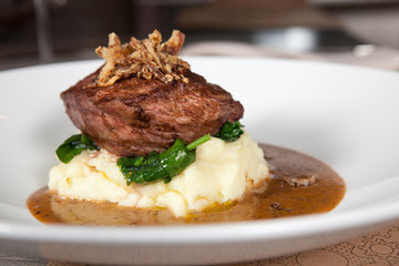 mashed potato with meat on a white plate in a restaurant