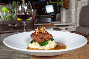 mashed potato with meat on a white plate in a restaurant