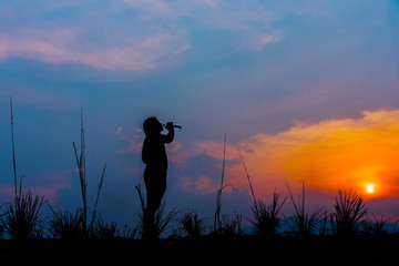 A silhouette of a girl drinking water.Refreshment