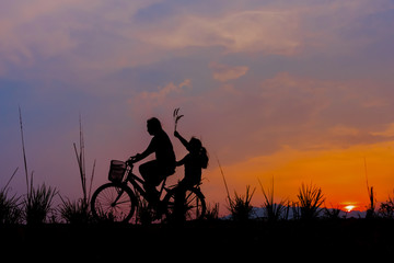 Fototapeta na wymiar silhouette of a girl riding on a trail with his bike.