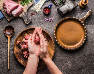 Female hands making meat balls on kitchen table background with  meat, force meat , meat grinder and spoon, top view. Cooking,recipes and eating concept - Powered by Adobe