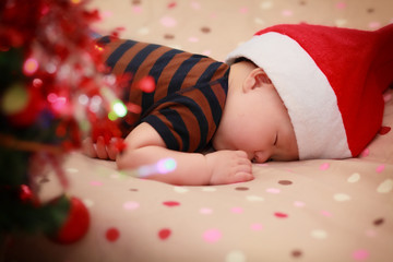 sleeping baby wearing Santa hat