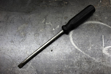 Black screwdriver on gray metal background
