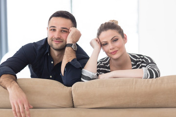 Portrait of young couple sitting on sofa