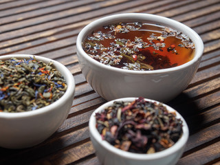 Tea of different kinds is poured into light cups.