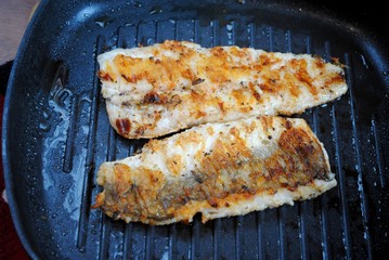 Fish hake cooked in a grill pan at home. Grilled fish