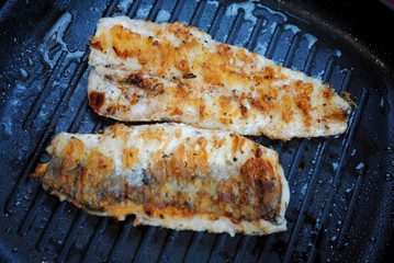 Fish hake cooked in a grill pan at home. Grilled fish