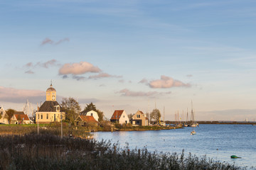 Fototapeta premium Protestant church in Durgerdam and houses overlooking the IJsselmeer