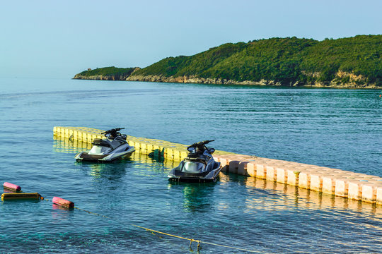 Two hydrocycles near a temporary floating berth on the coast. Water sports. Leisure.