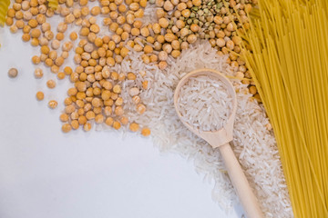 Set of products with complex carbohydrates on white background. wooden spoon, a range of cereals, pasta. Gluten free flour and cereals millet, green buckwheat, basmati rice,up view