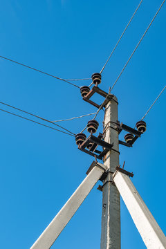 Triple support concrete electric pole against the sky
