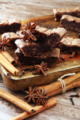 chocolate brownie cake dessert with cinnamon and spices on a wooden background.