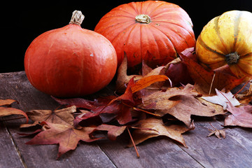 Thanksgiving background: pumpkins and fallen leaves on wooden background. Halloween, Thanksgiving...