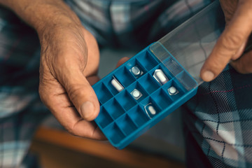 Elderly hands holding pillbox