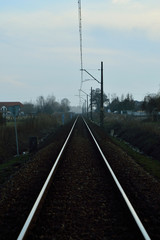 Fototapeta na wymiar Tory kolejowe, przewody i przejazd kolejowy. 
