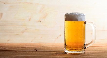 A glass of beer on a wooden table, copy space