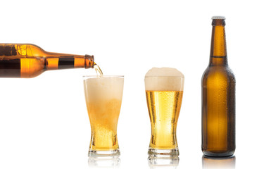 Bottles and glasses of beer on white background