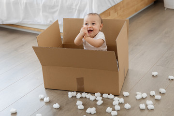 Happy baby sitting in delivery box