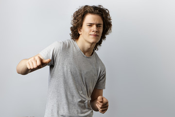 I'm the best. Choose me. Attractive narcissistic young man posing in studio in casual wear making...