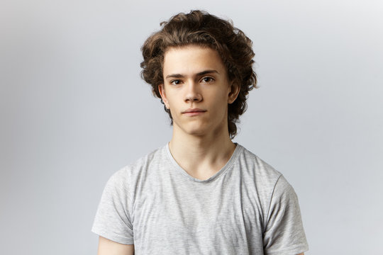 Picture of handsome young smoothly shaven Caucasian male actor with wavy  hair and brown eyes looking at camera with calm facial expression before  audition for role in play. People and lifestyle Stock