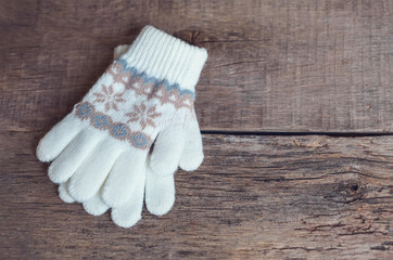 Winter children's mittens lie on a wooden background.Hygge