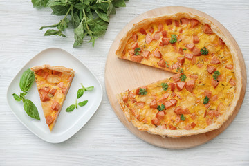 Composition with delicious sausage casserole on light wooden background
