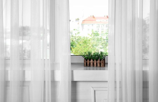 Window sill with beautiful modern curtains in room
