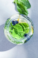 Jar of infused water with fruits and berries on table