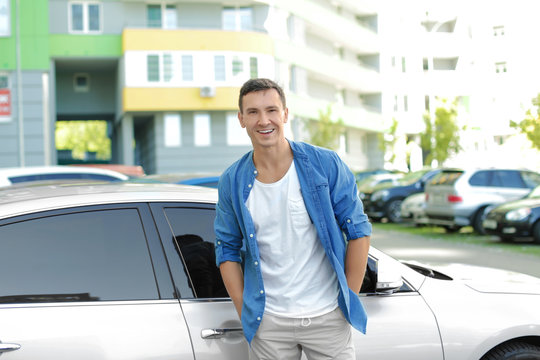 Man in casual clothes standing near car