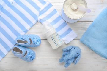 Composition with feeding bottle of baby milk formula on wooden table