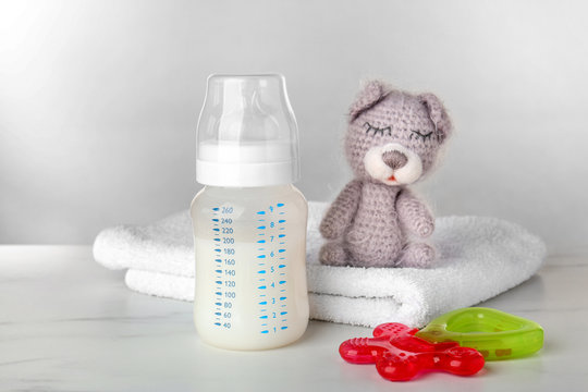 Composition with feeding bottle of baby milk formula on table