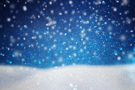 abstract image of flying snow over dark blue background, winter season