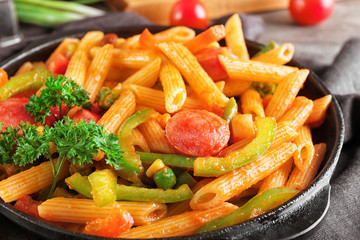 Pasta with sausage in portioned frying pan, closeup