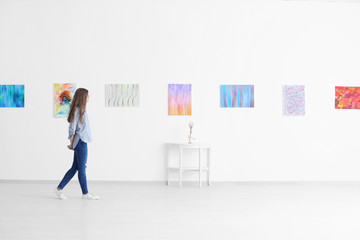 Young woman in art gallery - obrazy, fototapety, plakaty