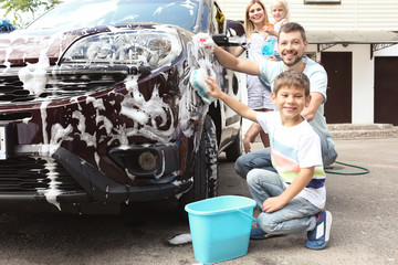 Happy family washing car outdoors
