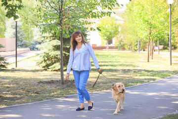 Mature woman walking her dog in park