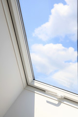 A modern roof mansard window against blue sky