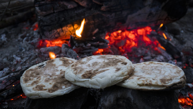 breads warming in campfire