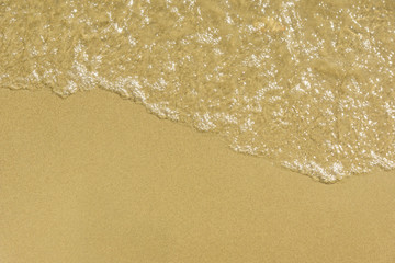Fototapeta na wymiar Soft waves on a sandy sea beach - top view, copy-paste