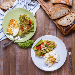 omelette with vegetable salad in colored plates on a wooden background
