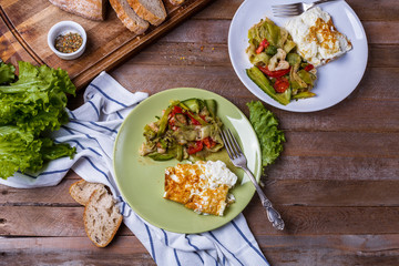 omelette with vegetable salad in colored plates on a wooden background
