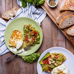 omelette with vegetable salad in colored plates on a wooden background