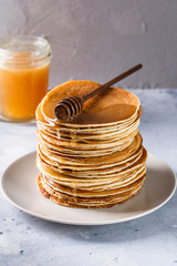 Pancakes with honey on a gray background