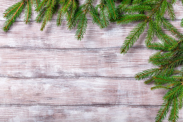 green fir branches on a light wooden background, horizontal