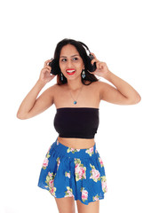 Young woman standing, listening to music