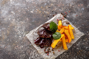 Pieces of beef poured with sauce and French fries.